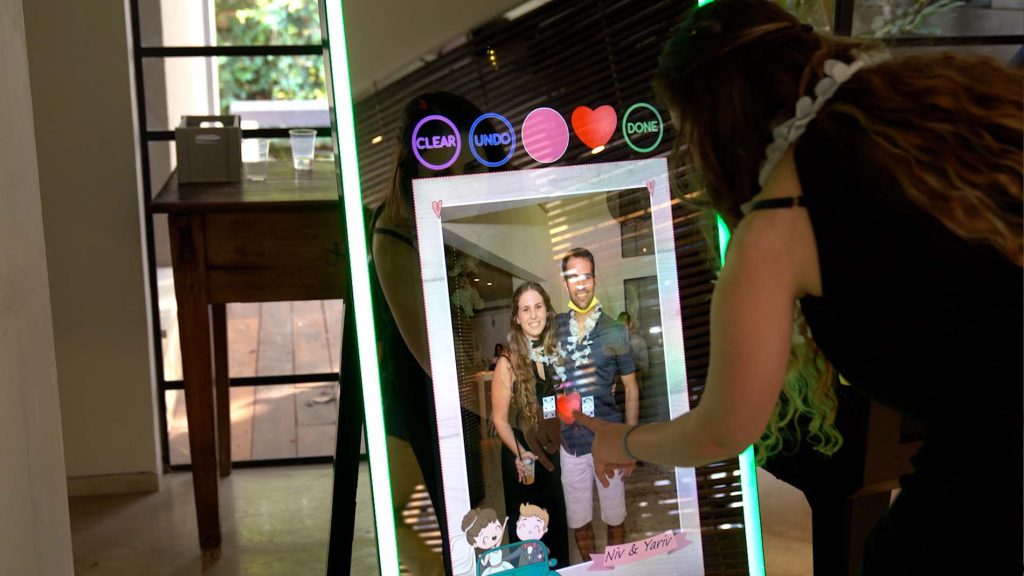 A couple visualized in the screen of a glass screen photo booth