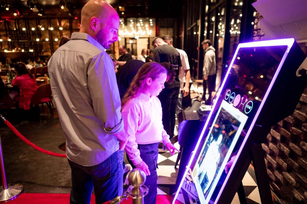 Father and child interacting with a Mirror Air Photo Booth